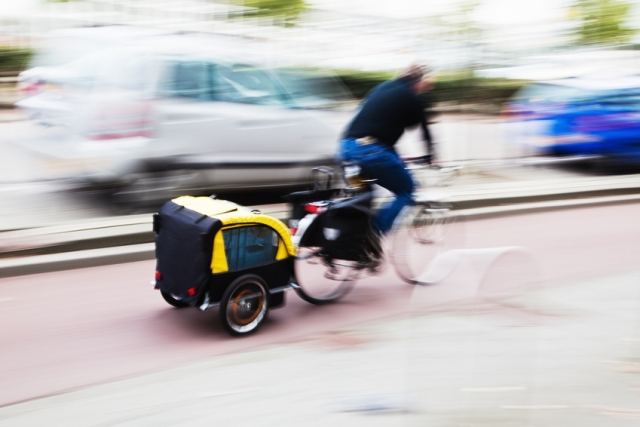 ein Fahrrad mit Anhaenger im Strassenverkehr