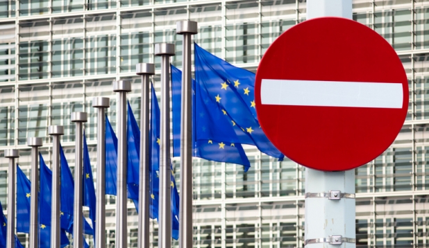 Gebaeude der EU-Kommision mit wehenden EU-Fahnen und einem Einfahrt Verboten Verkehrsschild im Vordergrund