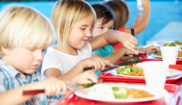 Kinder sitzen an einem Tisch und Essen